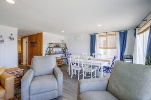 Ein gemütlicher Wohnbereich mit Esstisch, Stühlen und einer Couch.