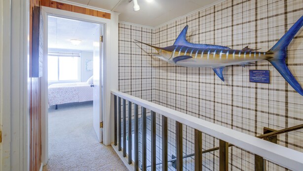 A hallway with a mounted fish on the wall, a bed, and a staircase. - Direct Beach Access, 2 Mi to Chinook Winds Casino (Lincoln City)