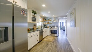 A modern kitchen with white cabinetry, stainless steel appliances, and a wooden floor. - Direct Beach Access, 2 Mi to Chinook Winds Casino (Lincoln City)