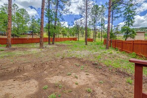 A fenced outdoor area with trees and a clear sky. - 8 Mi to Ruidoso Downs! Family Cabin w/ Deck & Yard (Ruidoso)