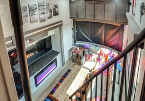 A modern interior with a fireplace, seating area, and artwork on the walls. - Hot Tub & Mtn Views! Carlsbad RV Retreat (Carlsbad)