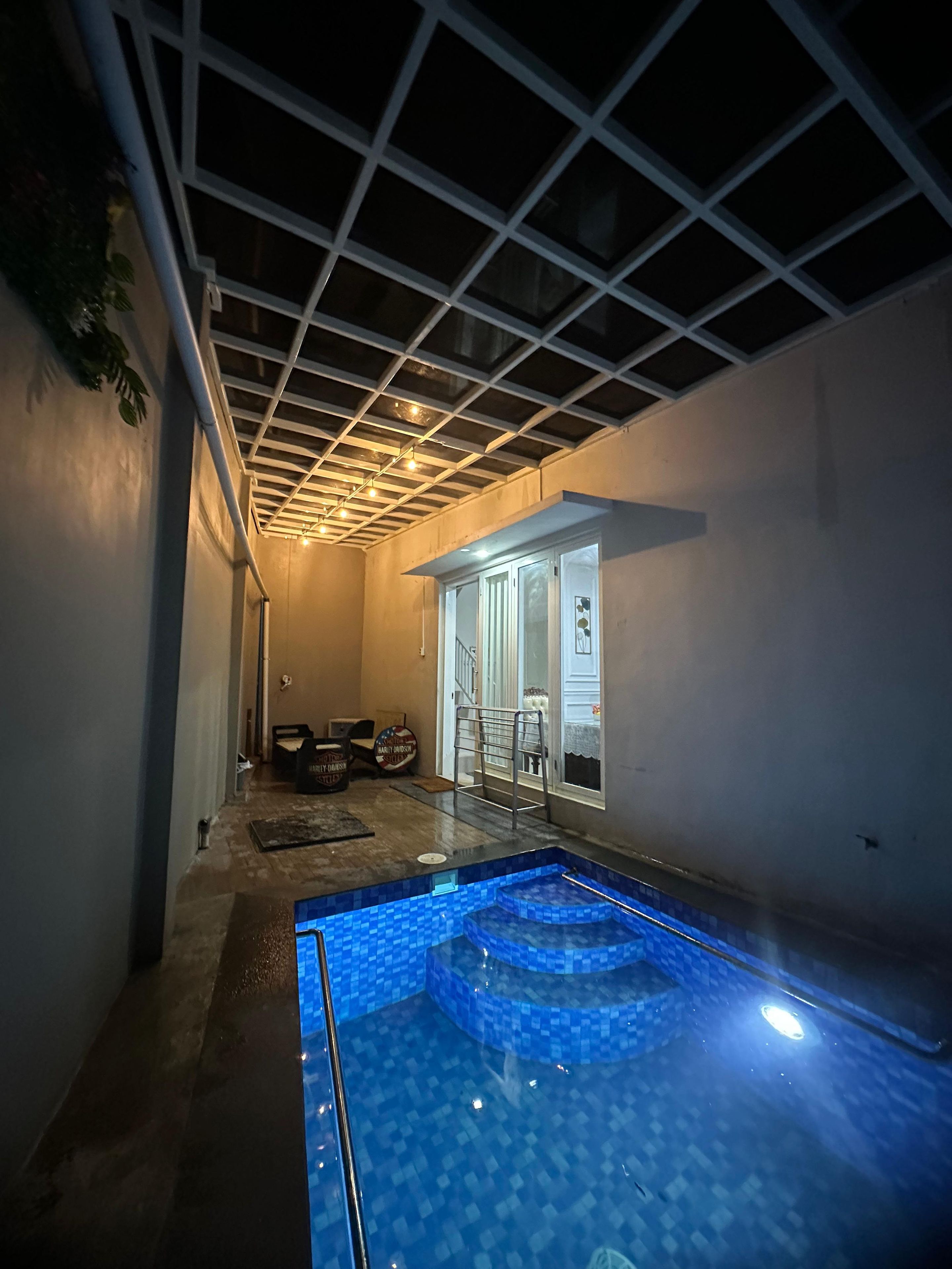 A swimming pool with a tiled floor and a ceiling with a grid pattern.