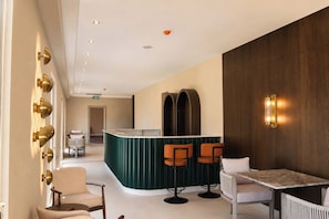 A hotel lobby with a reception desk, seating area, and a wooden wall.
