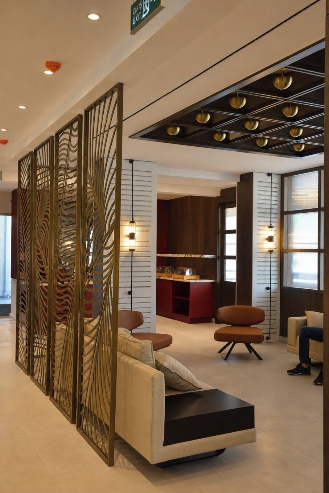 Rebedor modern amb taulell de recepció, zona de seients, panells decoratius i sostre amb il·luminació empotrada.