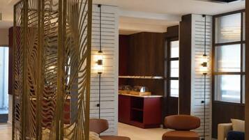 Rebedor modern amb taulell de recepció, zona de seients, panells decoratius i sostre amb il·luminació empotrada.