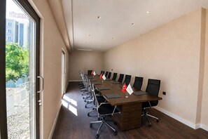 A conference room with a long table, chairs, and flags.
