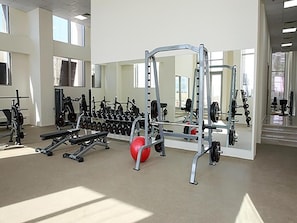 Ein Fitnessraum mit Gewichthebezeugen, einer Bank und einem roten Medizinball.