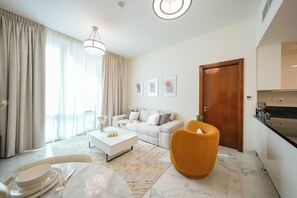 Ein modernes Wohnzimmer mit Sofa, Couchtisch und Essbereich für zwei Personen.