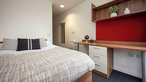 A bedroom with a bed, a desk, and a red accent wall. - Student Only Apollo Works (Coventry)