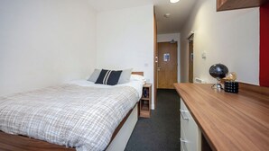 A bedroom with a bed, a bedside table, a desk, and a globe. - Student Only Apollo Works (Coventry)