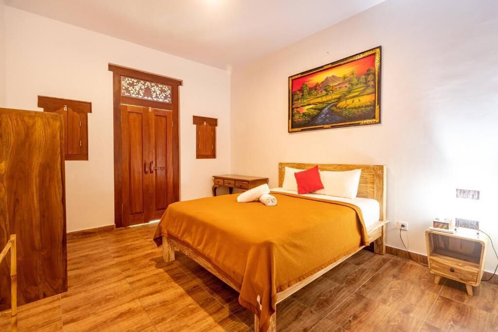 Un dormitorio con cama de madera, una mesita de noche, un cuadro y un armario.