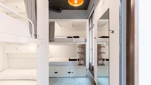 A compact room with bunk beds and a wardrobe. - Black Swan Hostel Granada (Granada)