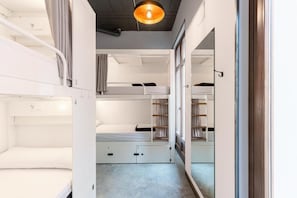 A compact room with bunk beds and a wardrobe. - Black Swan Hostel Granada (Granada)