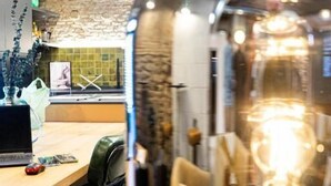 A modern interior with a wooden table, green chairs, and a decorative glass object. - Black Swan Hostel Granada (Granada)