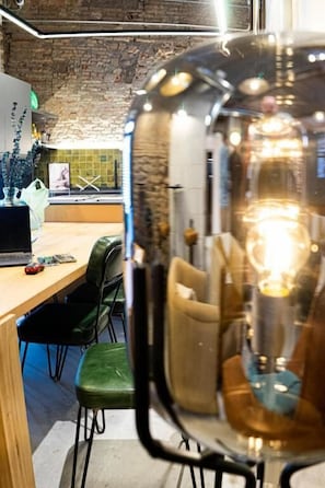 A modern interior with a wooden table, green chairs, and a decorative glass object. - Black Swan Hostel Granada (Granada)