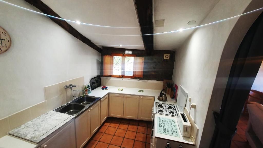 Una cocina compacta con lavamanos, estufa y armarios.