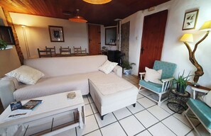 A living room with a sofa, a coffee table, a side table, a lamp, and a chair. - Casa Mauri (Santa Engràcia)