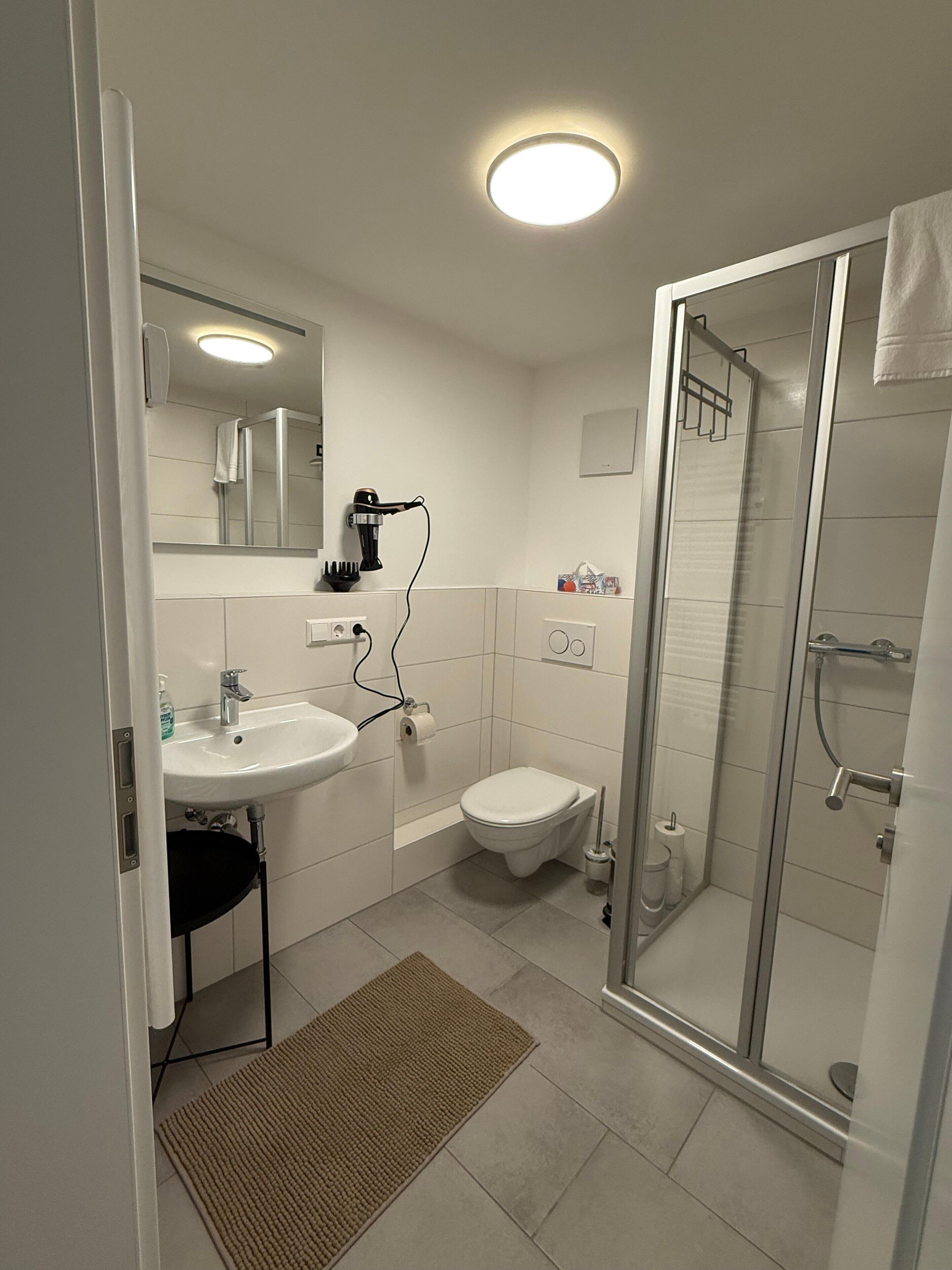 Ein modernes Badezimmer mit Waschbecken, Toilette und Duschkabine.