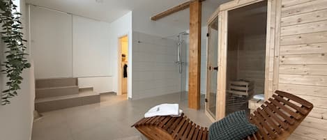 Un interior moderno con un banco de madera curvo, ducha de vidrio y una escalera que lleva a un segundo nivel.