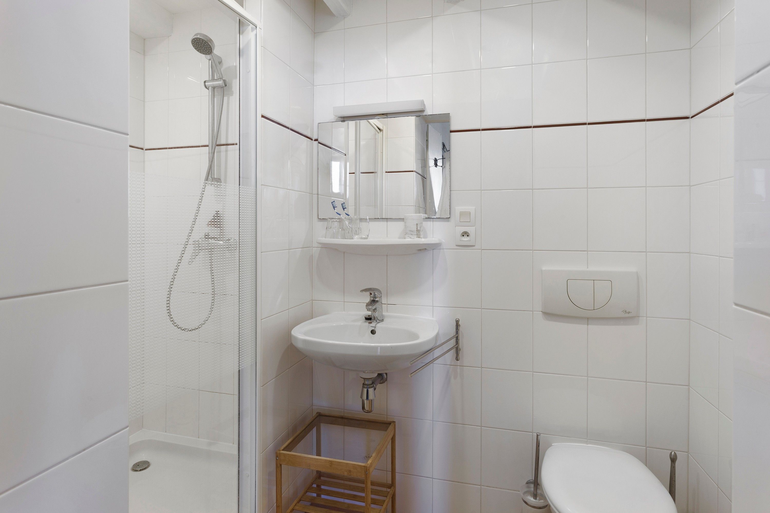 Een badkamer met een douche, wastafel en toilet.
