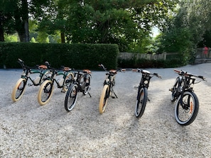 A row of bicycles parked on a gravel surface.