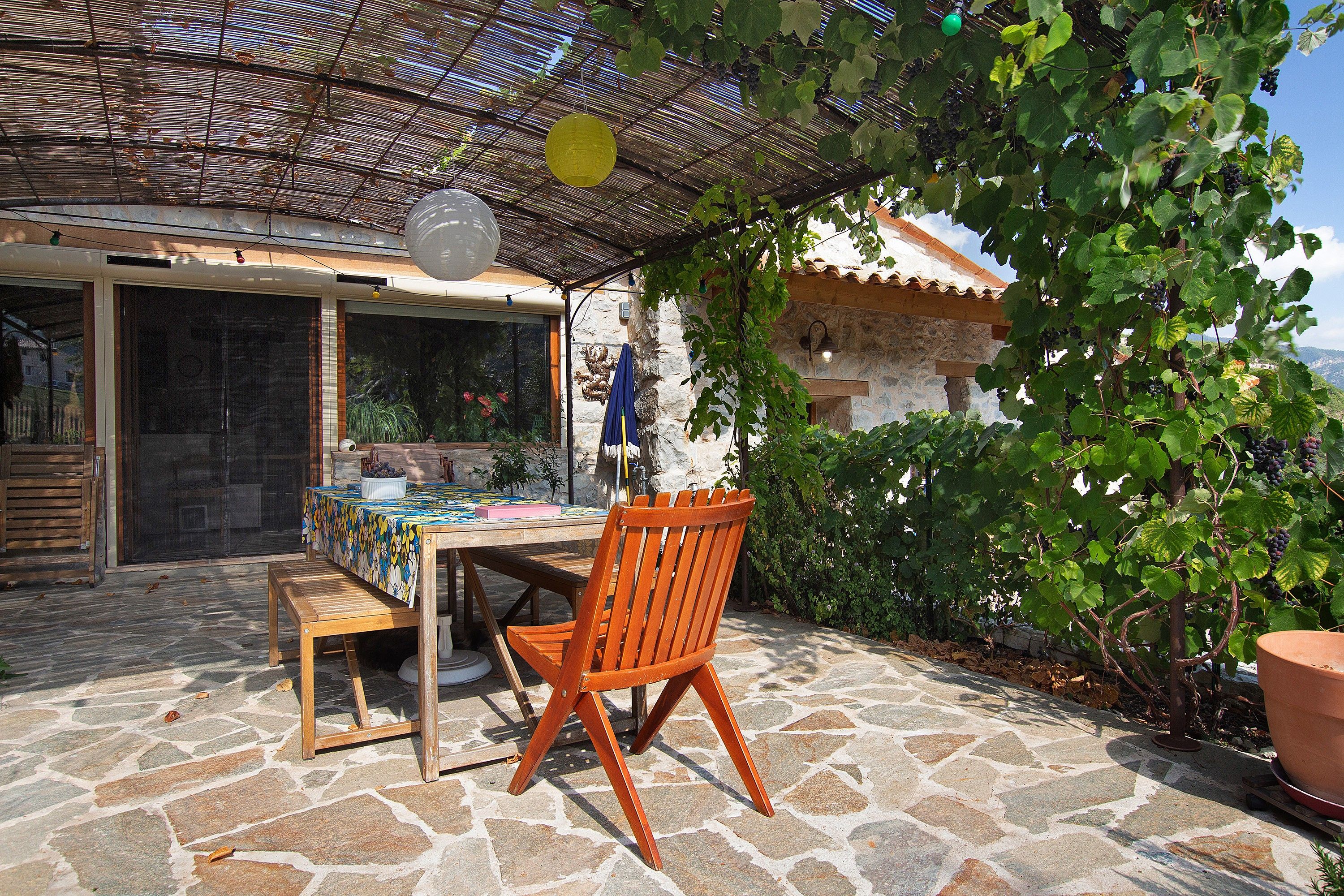 Une terrasse extérieure avec une table, des chaises et une pergola.