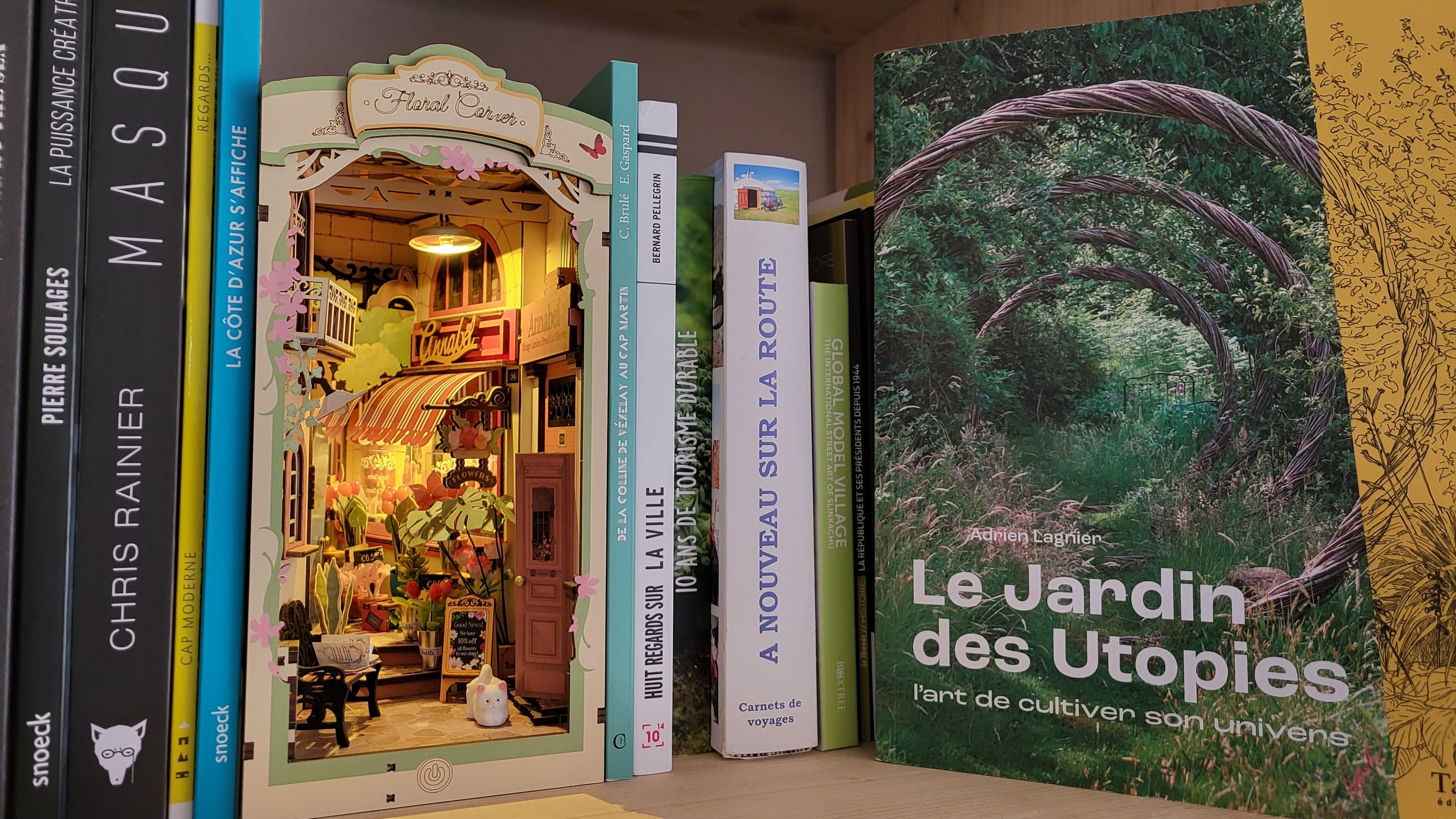 Une bibliothèque remplie de livres et une décoration florale évoquant une boutique de fleurs.