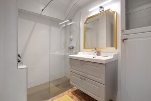 A modern bathroom with a glass shower enclosure, a white sink with a gold-framed mirror, and a tiled floor. - Country house 'La Bergerie du Grand Tilleul' with Mountain View, Private Garden, Wi-Fi (Val-de-Chalvagne)