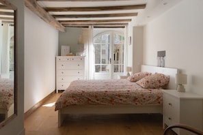A bedroom with a bed, dresser, and a mirror.