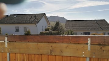 Un quartier résidentiel composé de deux maisons, l’une avec un toit en tuiles et l’autre avec un toit plat, séparées par une clôture en bois.