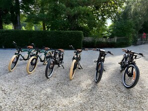 A row of bicycles parked on a gravel surface.