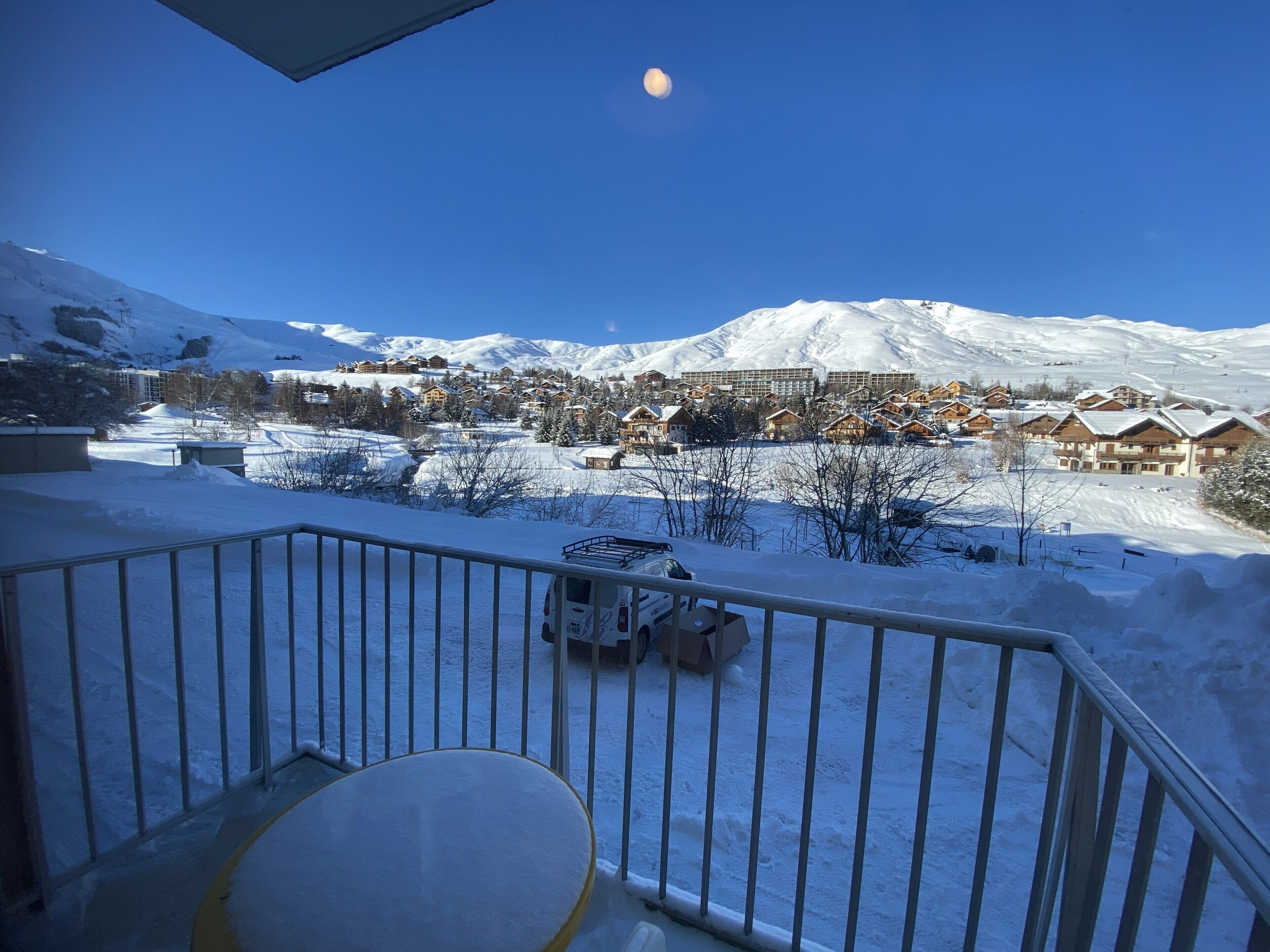 A snow-covered mountain landscape with a clear sky and a visible moon.