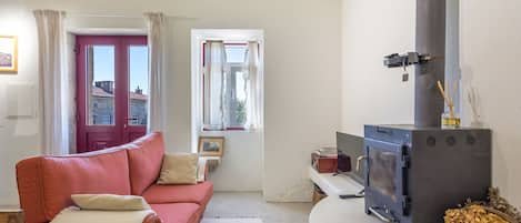 Un salon chaleureux avec un canapé, une cheminée et une vue sur l’extérieur.