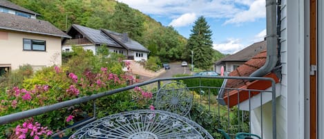 Un quartier résidentiel avec des maisons, un jardin agrémenté de fleurs roses et une rambarde en métal.