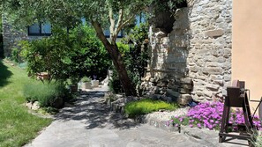 A stone pathway leading through a garden with various plants and flowers. - Apartment 'Ca Di Buie' with Private Terrace, Garden, Pool and Wi-Fi (Monastero Bormida)