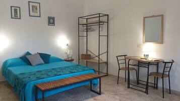 Une chambre à coucher comprenant un lit, une table de chevet, une lampe et un bureau avec des chaises.