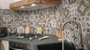 Una cocina con estufa a gas, un lavamanos y un salpicadero decorativo.