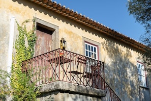 Un edifici amb un balcó, una finestra i una porta.
