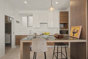 Una cocina moderna con una isla central, una lámpara colgante y armarios de madera.