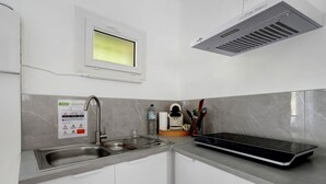 A modern kitchen with a built-in microwave, a stainless steel sink, and a window above the sink.