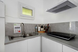 A modern kitchen with a built-in microwave, a stainless steel sink, and a window above the sink.