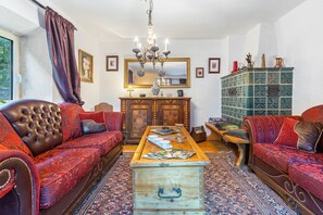 A traditional living room with a sofa set, a wooden coffee table, and a cabinet.