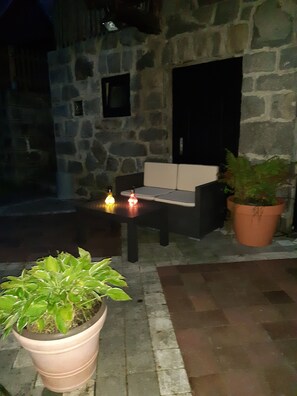 Ein Außenbereich mit Steinsäulen, einem Blumentopf und einem Tisch mit Kerzen.