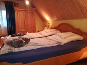 A bedroom with a wooden ceiling, a bed with white bedding, and a nightstand with a lamp. - Holiday Home Madlholz with Private Terrace and Garden (Geiersthal)