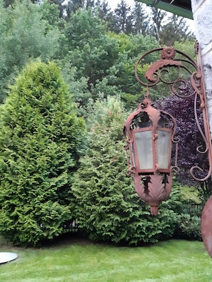 A garden with a decorative metal lantern and lush green foliage. - Holiday Home Madlholz with Private Terrace and Garden (Geiersthal)