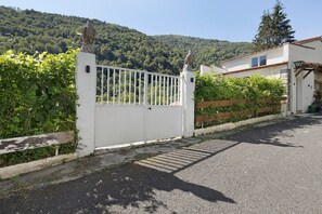 A gated property with a white fence, a stone base, and a wooden gate.