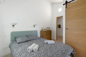 Un dormitorio con cama, cómoda y puerta.