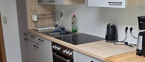 A modern kitchen with a built-in oven, a microwave, and a coffee maker.