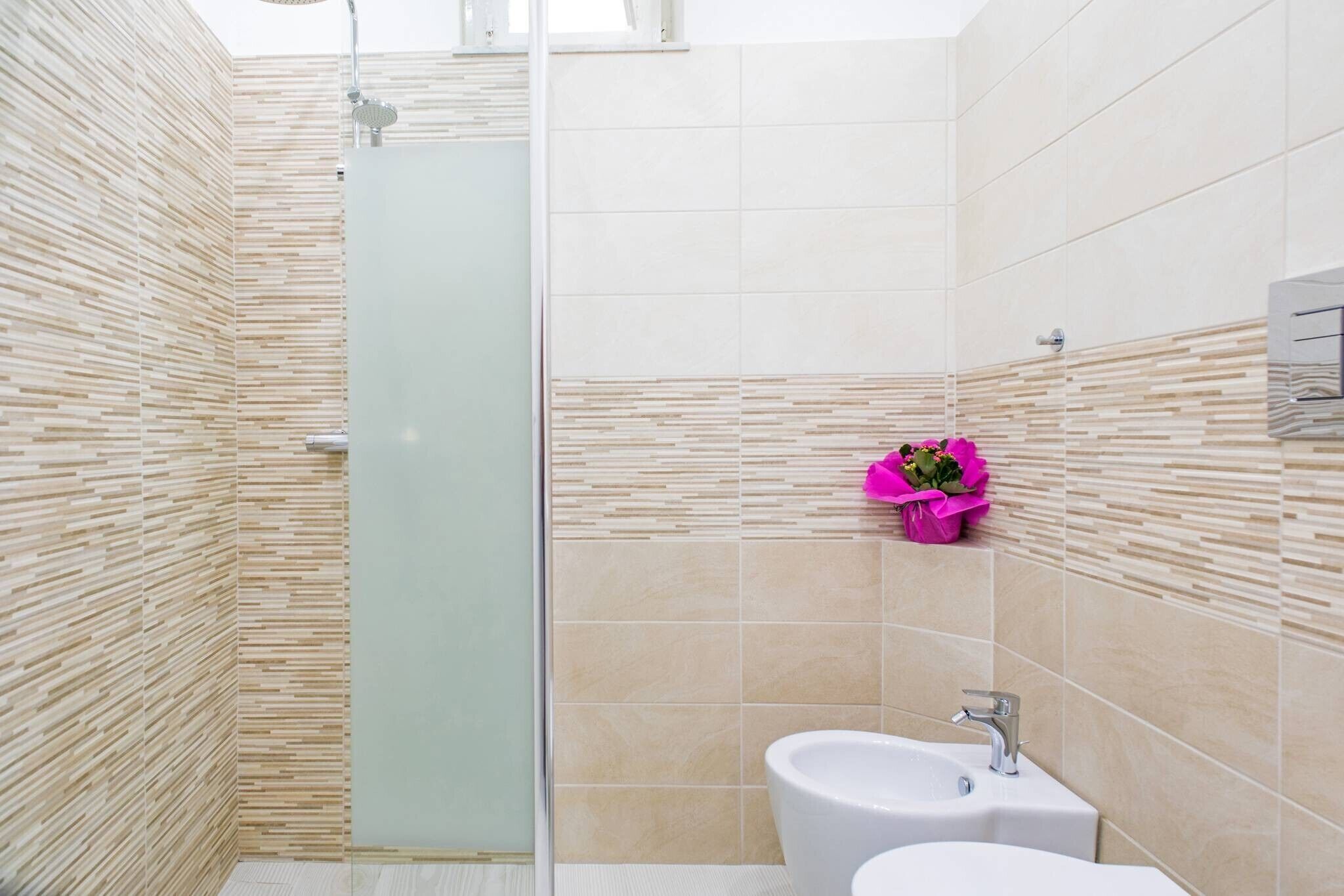 Ein modernes Badezimmer mit Dusche, Waschbecken und Toilette.