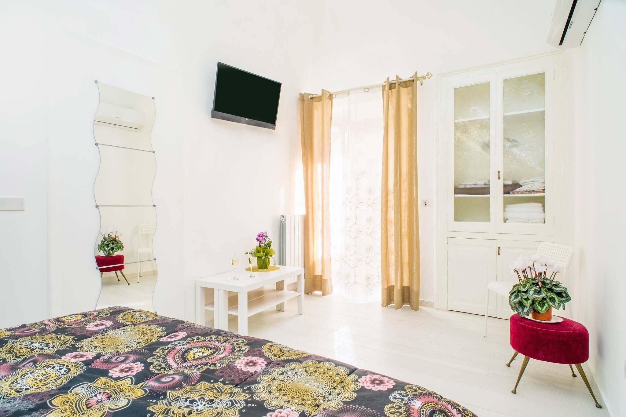 Une chambre d’hôtel comprenant un lit, un bureau, une chaise, une télévision et une armoire.